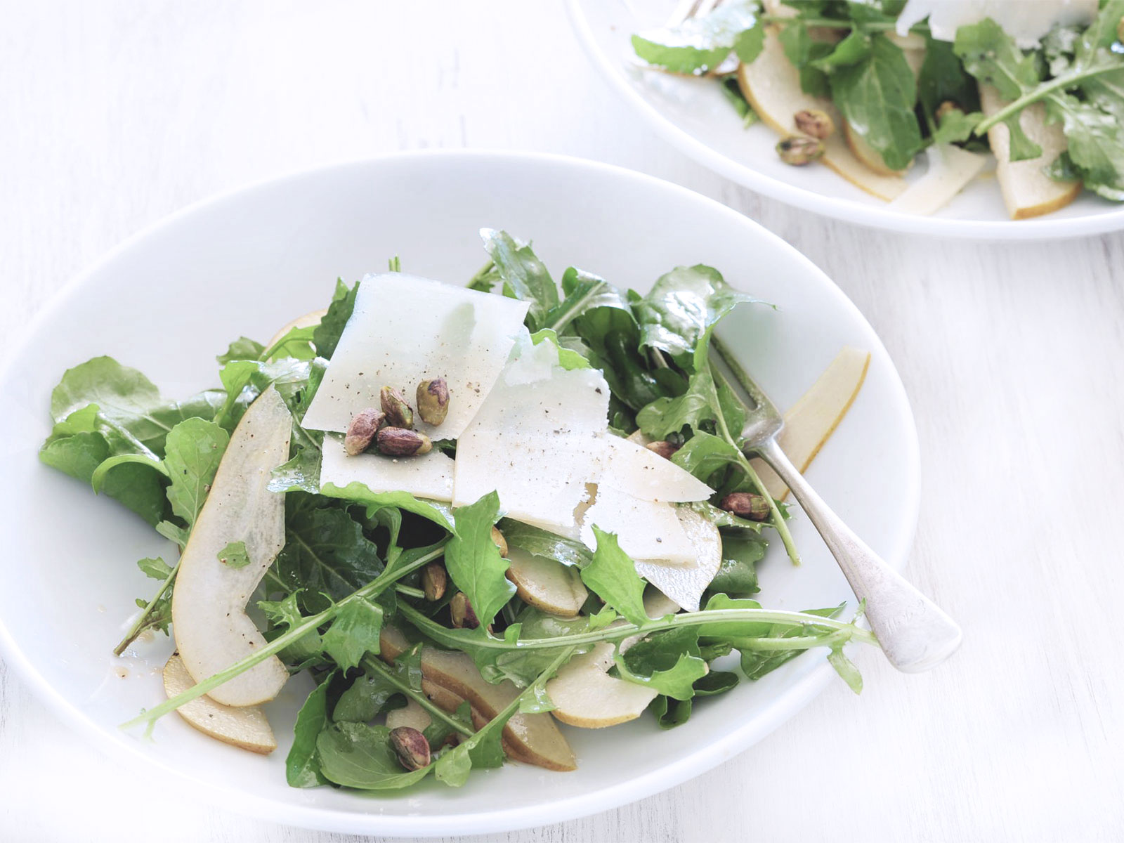 Finely sliced raw artichoke hearts and rocket lettuce topped with parmesan cheese