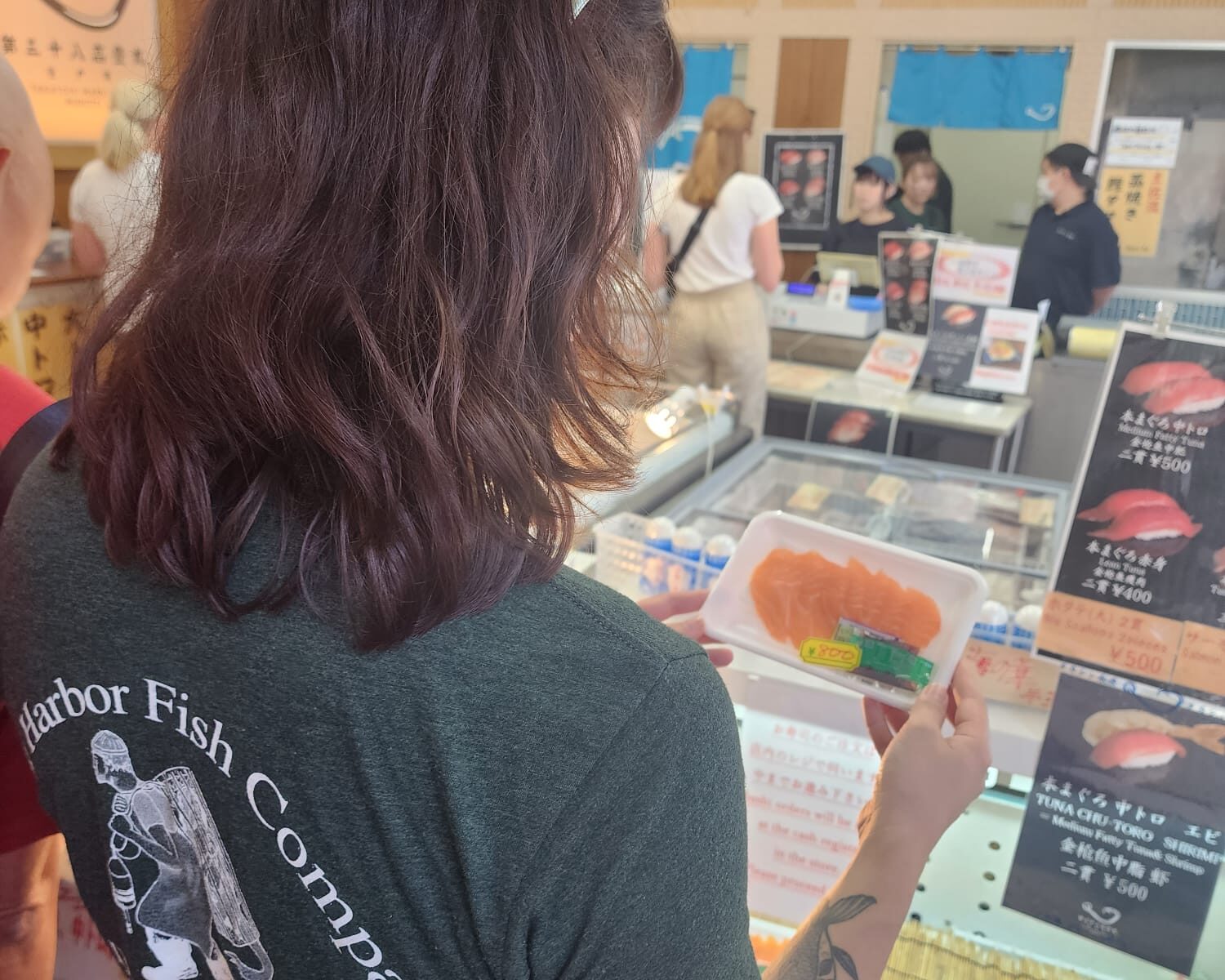 Kylie hand selecting fresh fish from Tsukiji Market in Japan